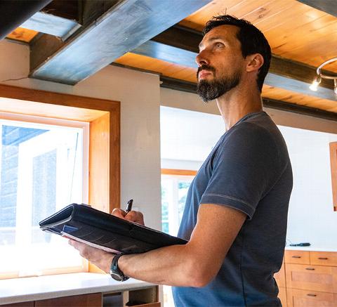 man inspecting building interior making notes